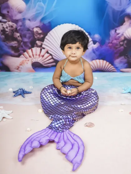 Holding a tiny seashell, she is completely in her element. My studio is stocked with props to make every theme feel real.