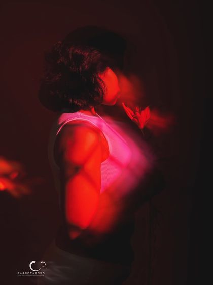 A profile view in a sea of red light and motion. This abstract portrait focuses on silhouette and color to evoke a powerful, emotional response.