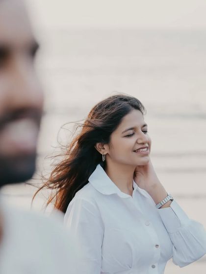 The sea breeze in her hair, a genuine smile. This is a perfect example of a candid moment that feels natural and effortless.
