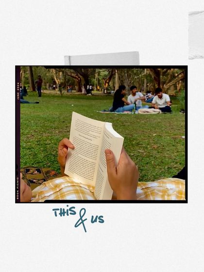 This and us: a thread. A person reading a book while lying on the grass in a park.