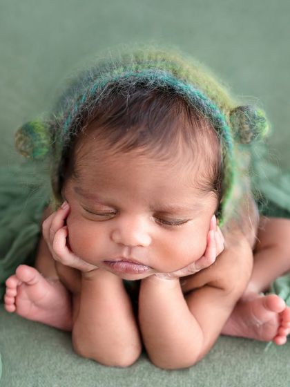 The classic "froggy pose," showcasing a newborn's sweet, sleepy face. This composite shot is always done with the highest regard for baby's safety and comfort.
