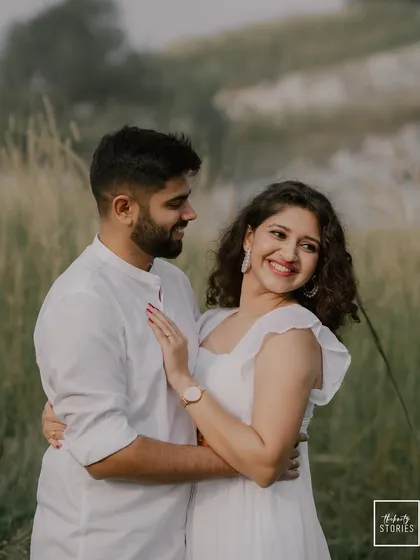 A beautiful candid photo of the couple sharing a look of love amidst a natural, rustic setting. Her smile and his fond gaze make this a perfect capture of their bond.
