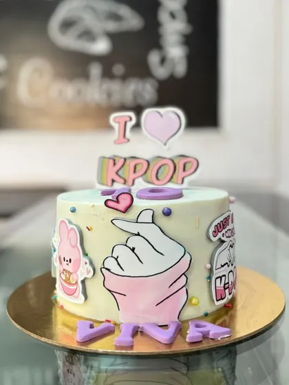 An "I Love K-Pop" cake for a music fan. The design includes the iconic finger heart gesture and other fun elements related to the K-Pop world.