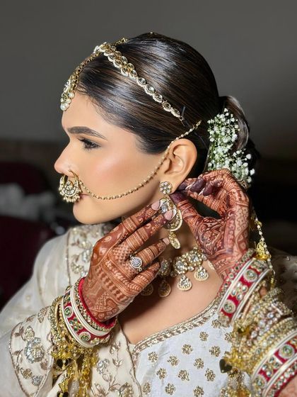 Getting ready moments are so special. Here, I'm putting the finishing touches on a sleek bridal bun, ensuring every strand is perfect before adding the floral accessories.