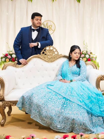 A stylish, posed portrait from an engagement party, showcasing the couple's elegance and the beautiful stage decor.