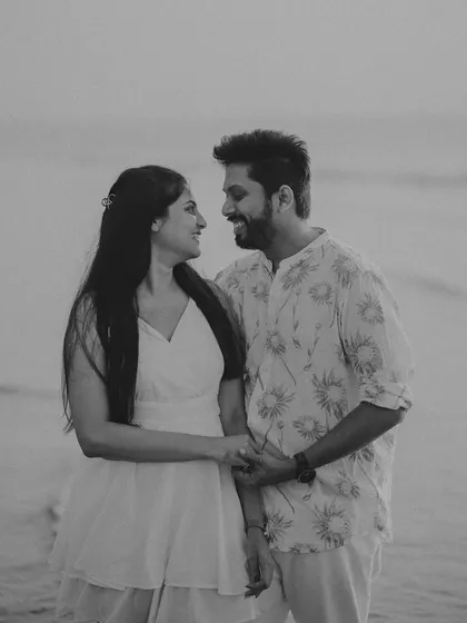 A timeless black and white portrait of a couple sharing a quiet moment. This intimate shot from a beach pre-wedding session focuses on their genuine smiles and connection.