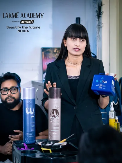 A professional trainer showcasing the products used during a hair treatment workshop. We ensure our students learn with industry-standard products.