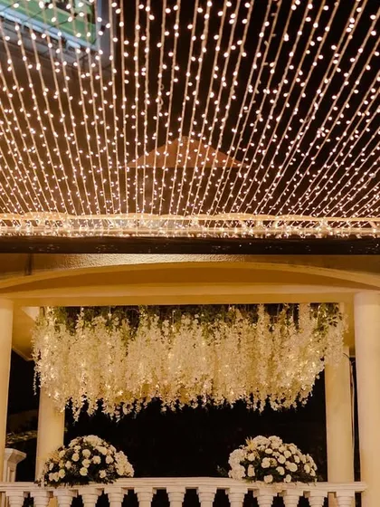 A canopy of fairy lights creates a magical ceiling for this outdoor wedding event.