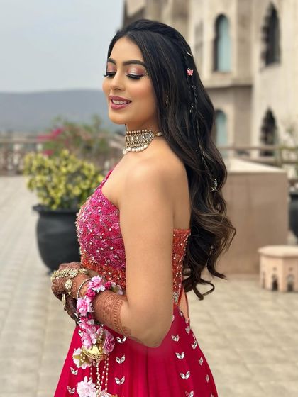 The client looking radiant with her playful carnival hairstyle, which is both stylish and secure for a day of fun.