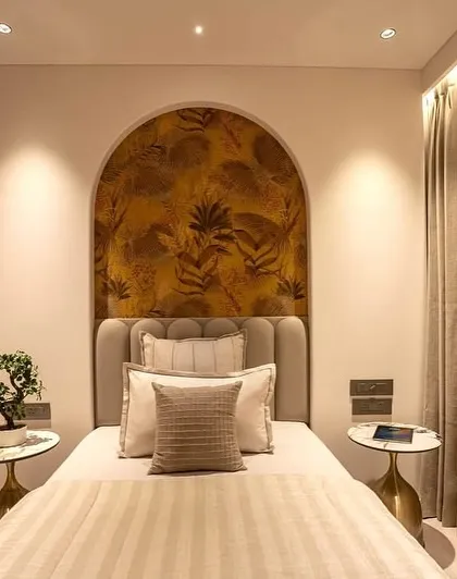 A compact and cozy bedroom in the Oberoi Sky City project. I used an arched, patterned headboard niche and warm, layered lighting to create a sense of depth and luxury in a smaller space.