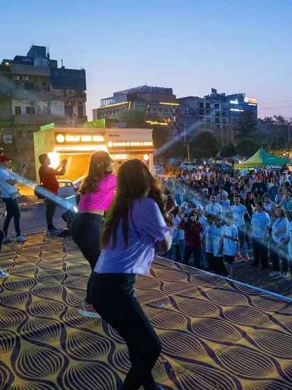 A side view of the stage at the Tealathon, with the crowd fully engaged in our Zumba session as the sun sets.
