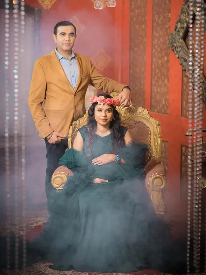 A dramatic, moody portrait of a couple in a studio setting. The use of smoke and elegant furniture creates a royal and timeless feel.
