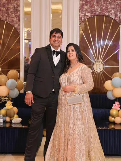 The same golden gown, looking absolutely radiant at a party. It’s a full-length, long-sleeved piece that exudes elegance and glamour.