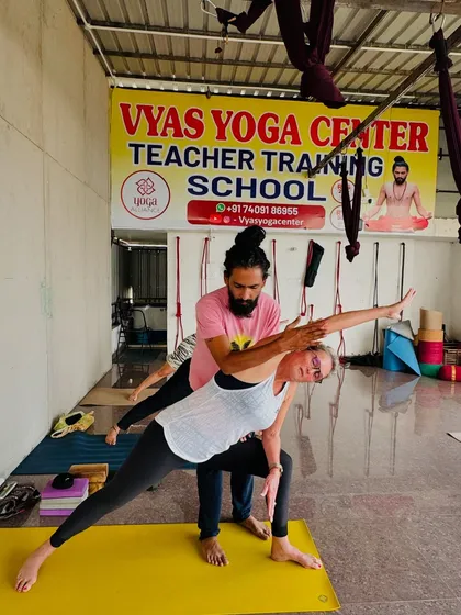 Our teaching philosophy is built on providing personal attention and correct alignment. Here, I am assisting a student in an extended side angle pose during our Teacher Training Course, ensuring she finds both stability and openness.
