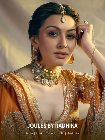 A royal portrait. Hansika Motwani wears a statement choker with unique pastel green stones and a matching hath phool, embodying the grace of a modern princess.