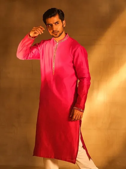 A full-length shot of a groom in a striking ombre kurta. The grooming is polished and refined, complementing the formal wear and ensuring he looks regal and put-together.