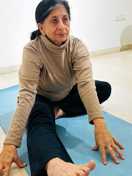 Age is no barrier to yoga. This student demonstrates a seated forward bend, showing that consistent practice brings flexibility and grace at any stage of life.