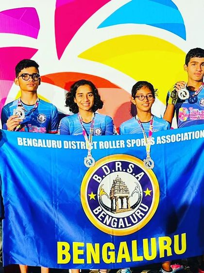 A great team photo with the Bengaluru District Roller Sports Association flag. Our skaters represent our district with immense pride and skill.