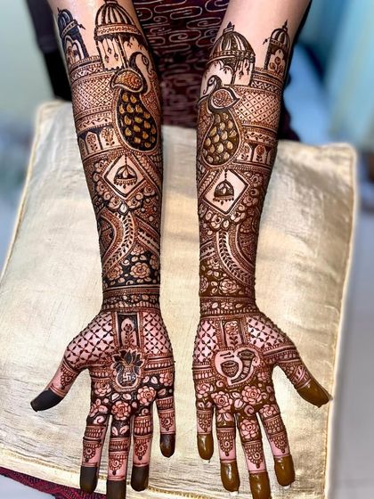 A majestic design with palace architecture and peacocks at the top, and hanging jhumka motifs on the arms.