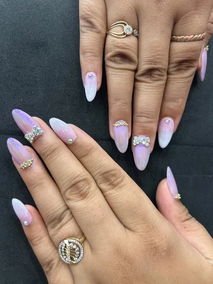 This photo displays the full set of iridescent ombre nails with rhinestone bows and accents. The combination of the chrome finish and sparkling gems creates a stunning, multi-dimensional effect.