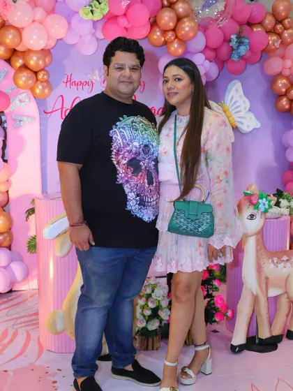 The parents of the birthday girl pose at her enchanting woodland-themed party.