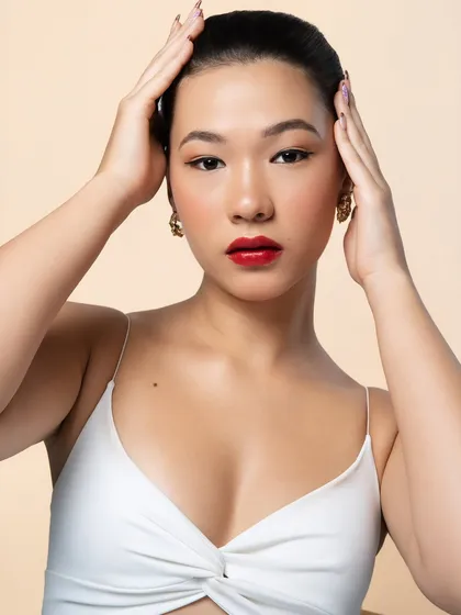 This pose highlights the clean lines of the high bun and the flawless application of the makeup, creating a look that is both strong and elegant.