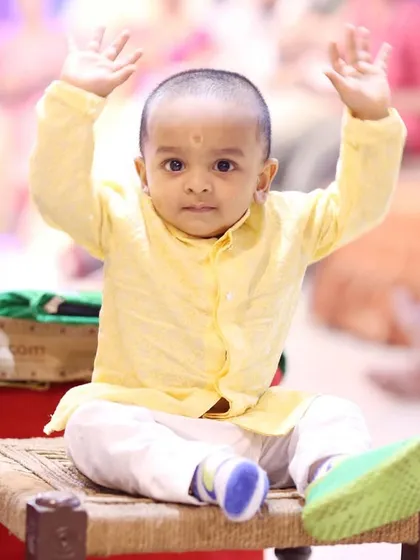 The birthday boy in his traditional yellow kurta, looking absolutely adorable during his first birthday ceremony.