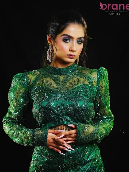 The full view of the green party dress with hair styled in soft, glamorous waves.