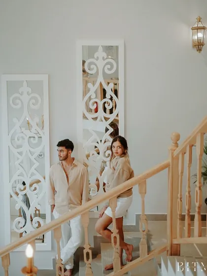 A posed but relaxed portrait on the villa staircase. This image showcases the elegant architecture and the couple's effortless style, making for a sophisticated pre-wedding photo.
