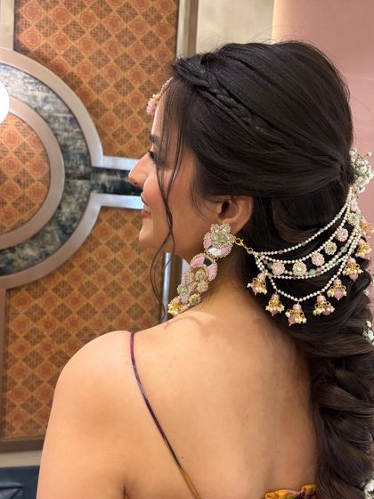 A close-up side view of the bridal braid. This angle highlights the layered hair accessory and how it's integrated with the braid and soft pieces around the face.