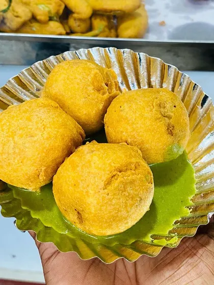 A plate of hot, fluffy Aloo Bondas served with my signature green chutney. I fry every batch in fresh oil, ensuring a perfect, non-greasy snack every time.