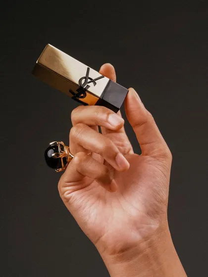 A clean, minimalist shot of my hand holding the YSL Rouge Pur Couture lipstick, highlighting its luxurious packaging.
