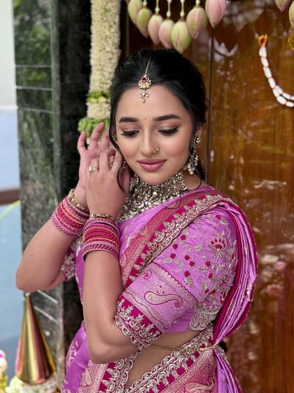 A candid shot of the client adjusting her earring, highlighting her beautiful henna and bangles.