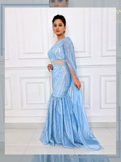 A side view of the ice-blue gown, showing the sheer, sparkling cape detail.