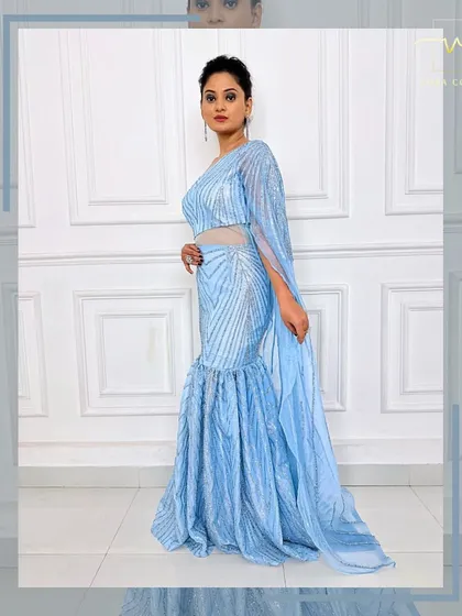 A side view of the ice-blue gown, showing the sheer, sparkling cape detail.