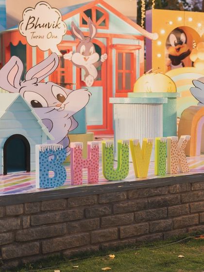 Custom "BHUVIK" name blocks in playful colors and patterns, part of the Looney Tunes stage decoration.