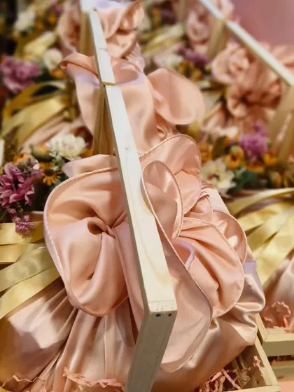 A close-up view of the satin-wrapped gifts inside the pinewood crates for Lakme. This furoshiki-style wrapping adds a unique, artisanal touch to corporate gifting.