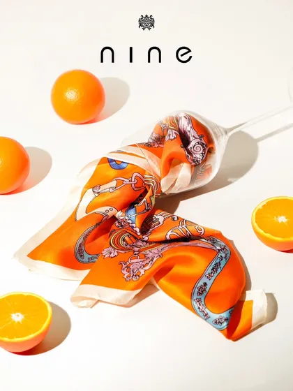 A pocket square can transform an outfit. This vibrant orange silk pocket square is artfully displayed to show its quality and design, representing our wide range of men's accessories.