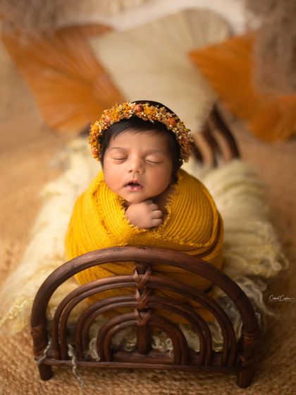 A full view of this rainbow bed setup. The warm yellow wrap and bohemian props come together to create a cheerful and stylish portrait.