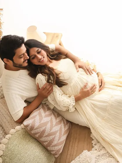 A peaceful and loving portrait. The couple relaxes together in a comfortable embrace, surrounded by soft pillows and textures, creating a serene and intimate scene.