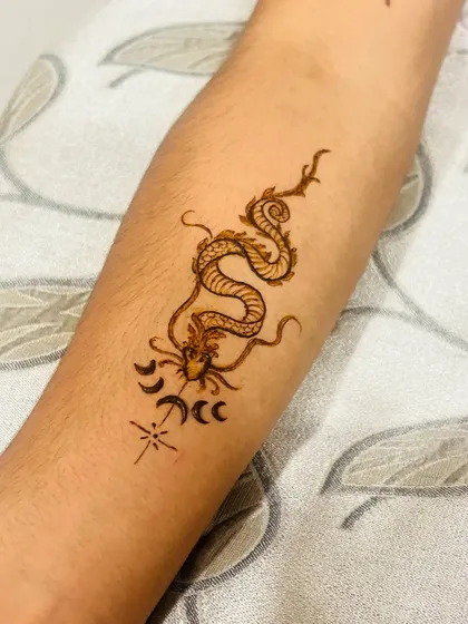 Mehendi isn't just for traditional patterns. I also create modern henna tattoos like this detailed dragon design on the forearm. It's a great way to have a temporary tattoo for a party or just for fun.