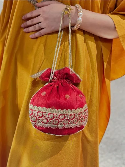 Another view of a red potli, this one featuring intricate gold embroidery, showcasing the variety of designs in my collection.