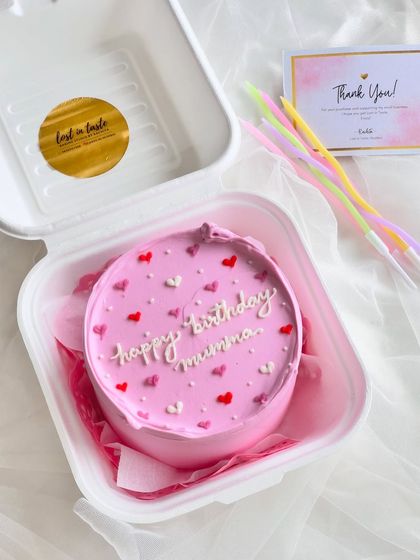 A sweet pink bento cake for a mother's birthday. The simple "happy birthday mumma" message is surrounded by multi-toned pink and red hearts.