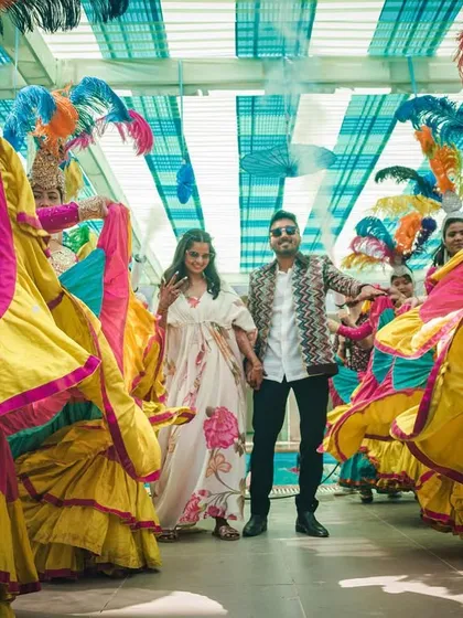 A candid moment of joy during the carnival entry. The couple enjoys the celebration as they are surrounded by a whirlwind of color and dance.