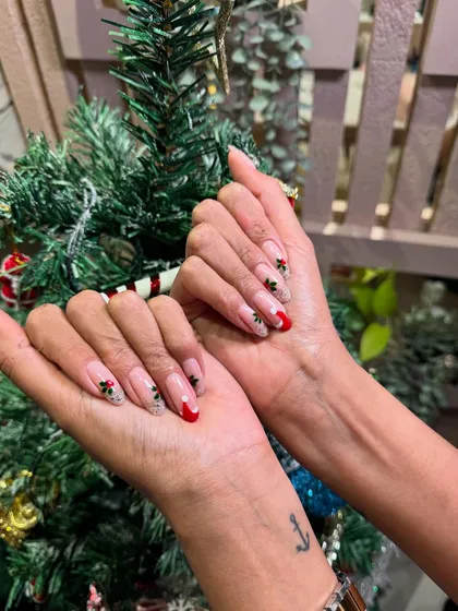 Getting into the holiday spirit with this festive Christmas design, featuring hand-painted holly on a classic French tip.