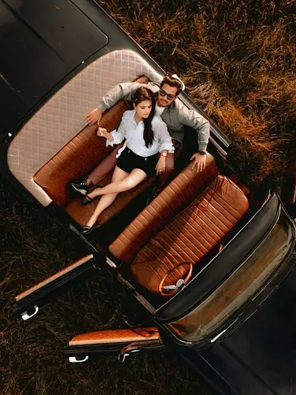 A unique aerial perspective of a couple in a vintage car, creating a stylish and editorial feel for their pre-wedding photoshoot.