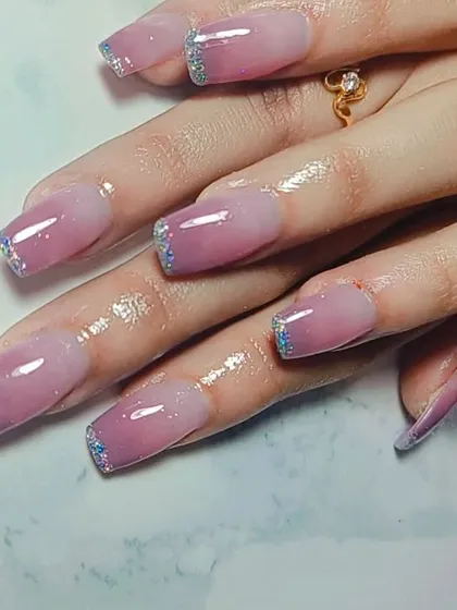 This design combines two popular styles: a soft pink ombre that fades into a sheer base, finished with a sparkling silver glitter French tip. It’s the best of both worlds.