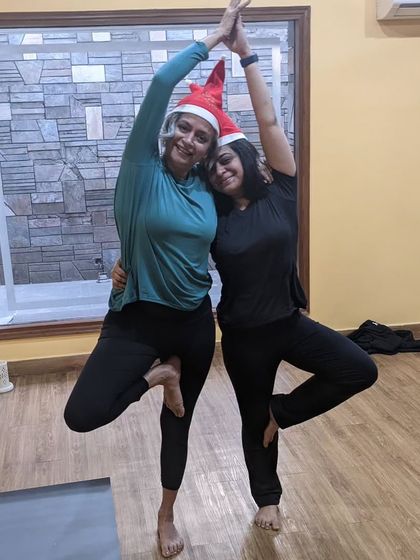 Merry Christmas from our yoga family. Finding balance and connection together in a partner tree pose, complete with Santa hats.