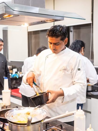 Concentration and precision. A chef plating up a dish during a busy event.