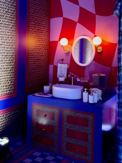 The bathroom decor for the sleepover party, with a red and white warped checkerboard wall, a modern blue vanity, and stylish lighting.